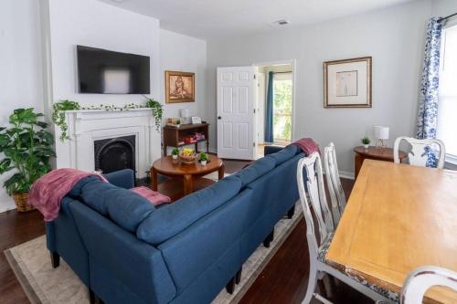 a blue couch in a living room with a table at Garden Penthouse in RVA! 3 Bedroom, 3 Bath! in Richmond