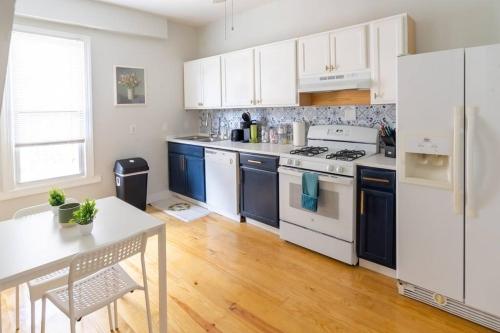 a kitchen with white appliances and a wooden floor at Garden Penthouse in RVA! 3 Bedroom, 3 Bath! in Richmond