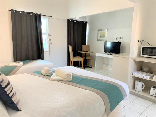 a hotel room with two beds and a television at Aqua Blue Motel in Gold Coast