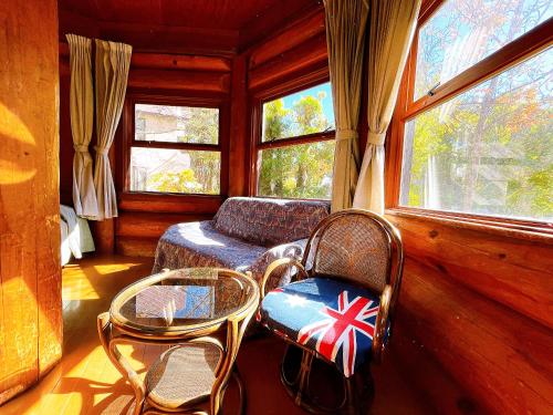 a room with two chairs and a table with a flag on it at Hakuba Pension & Log Hotel Meteor in Hakuba