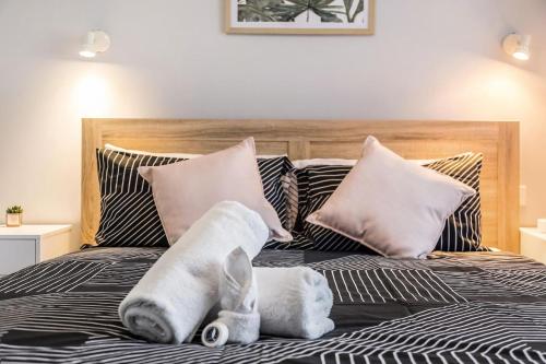 a bed with pillows and stuffed animals on it at Apartment 5B in Lennox Head