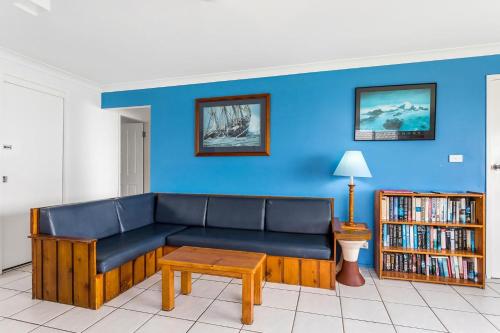 レノックス・ヘッドにあるAbsolute Beachfront Apartments 3Tの青いリビングルーム(ソファ、テーブル付)