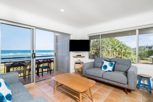 a living room with a couch and a table at Absolute Beachfront Apartment 4T in Lennox Head
