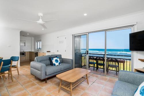 a living room with a couch and chairs and a table at Absolute Beachfront Apartment 4T in Lennox Head