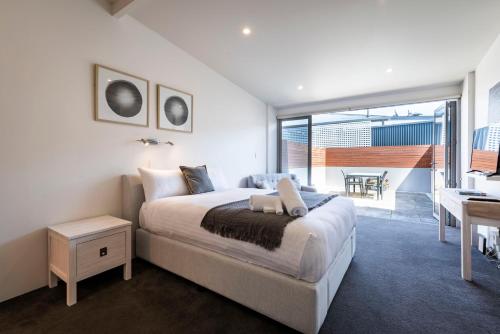 a bedroom with a bed with a desk and a balcony at Studio Apartment - 5 Minutes to Hobart CBD - Free Parking - Free WIFI in Sandy Bay