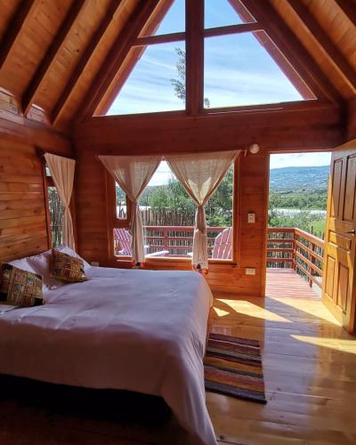 a bedroom with a large bed and a large window at El Ensueño in Villa de Leyva