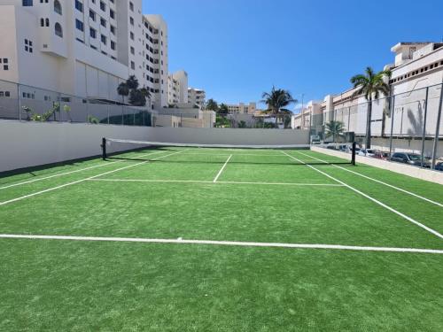 a tennis court with green grass on a building at Amazing Caribbean Ocean view at Villas Marlin in Cancun in Cancún
