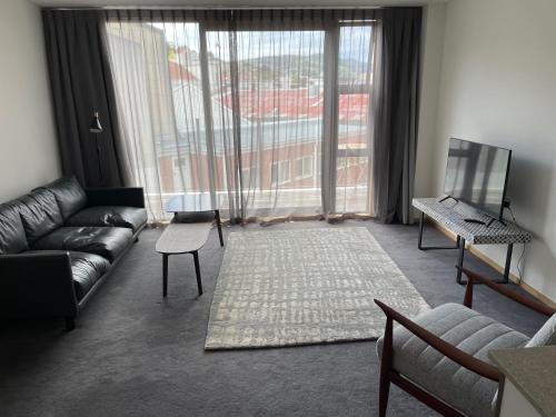 a living room with a couch and a large window at On Top Backpackers in Dunedin