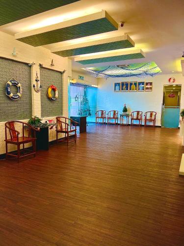a large room with wooden floors and tables and chairs at New World Express Motel in Bintulu