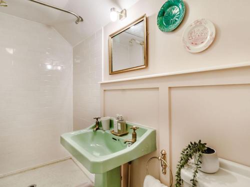 a bathroom with a green sink and a mirror at The Yellow Cottage On The Hill in Framlingham