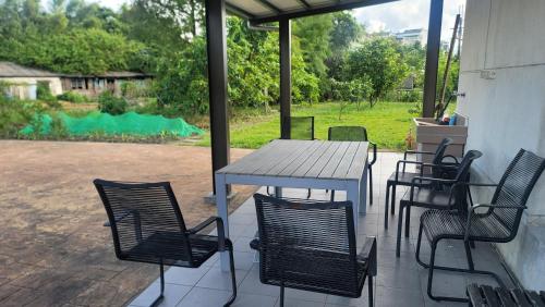 a table and chairs on a patio with a view of a yard at ChaoPingJia Fengge Guesthouse in Wujie