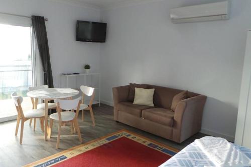 ein Wohnzimmer mit einem Sofa und einem Tisch in der Unterkunft Southern Comfort in Goolwa North