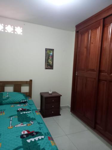 1 dormitorio con cama y armario de madera en Casa Gloria, en Medellín