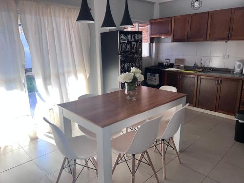 ポサーダスにあるHermoso duplex en barrio cerradoのキッチン(木製テーブル、白い椅子付)