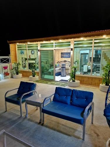 a patio with two blue couches and a table at Yaso Roof & Apartments in Amman