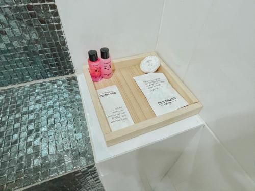 a bathroom with two pink bottles sitting on a shelf at Don Muang Hotel in Bangkok
