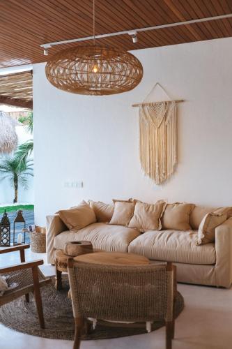 a living room with a couch and a chandelier at Amaka Villas in Uluwatu