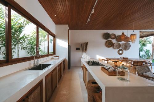 a kitchen with a sink and a counter with windows at Amaka Villas in Uluwatu