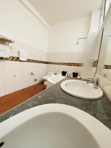 a bathroom with a sink and a toilet at Hotel Las Palmeras in Huacho