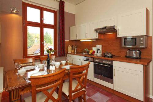a kitchen with a wooden table with chairs and a sink at Villa Maria Wohnung 06 in Ostseebad Koserow