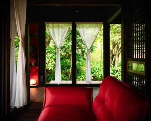 a red couch in a room with a large window at Traditional house, Blue moon villa, 古民家 蒼月庵 in Kimitsu