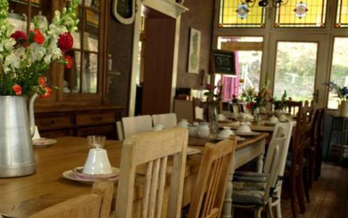 a dining room with a long table with chairs and flowers at Villa Warempel in Valkenburg