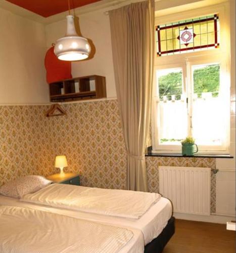 a bedroom with a bed and a window at Villa Warempel in Valkenburg