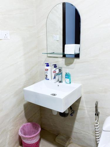 a bathroom with a white sink and a mirror at FORMOSA RESIDENCEN - The Apartments 2 Bed Room in Nagoya