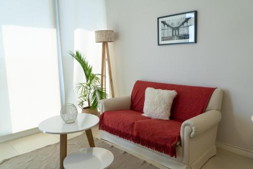 a living room with a red couch and a table at Increíble departamento con vista panorámica al río in Santa Fe