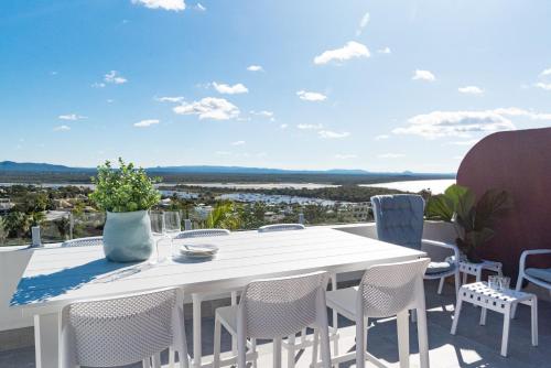 a white table and chairs on a balcony with a view at Bali Hai Apartments Noosa in Noosa Heads