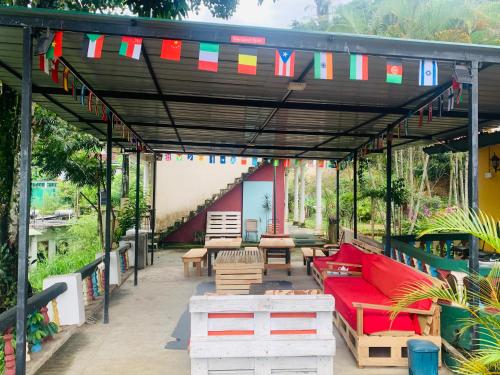 a patio with a red couch and tables and flags at Rock View Hostel Ella in Ella