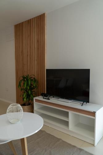 a living room with a tv on a white entertainment center at Increíble departamento con vista panorámica al río in Santa Fe