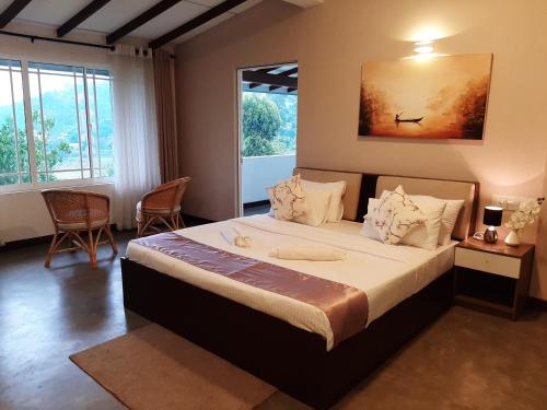 a bedroom with a large bed and a large window at Pekoe Lodge in Maskeliya