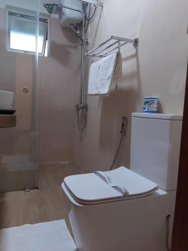 ein weißes Bad mit einem WC und einer Dusche in der Unterkunft Pekoe Lodge in Maskeliya