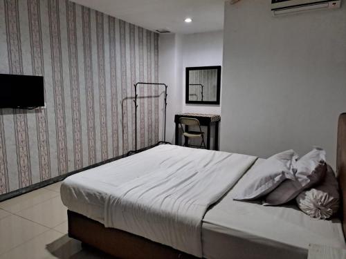 Un pat sau paturi într-o cameră la UNIK Guest House Syariah