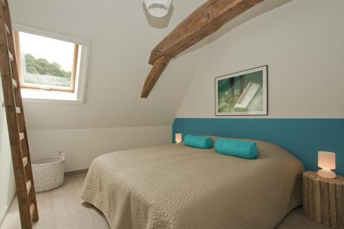 een slaapkamer met een bed met blauwe kussens bij Residence des Recollets Apartments in Durbuy