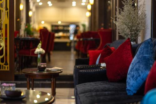 Flora Centre Hotel & Spa في هانوي: غرفة معيشة مع وسائد حمراء وزرقاء على أريكة