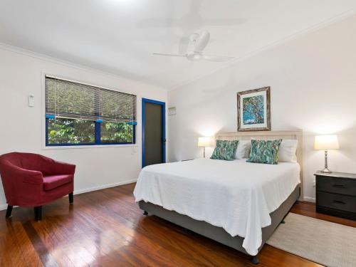 a bedroom with a bed and a chair and a window at Unit 3 Kookaburra Lodge 8 Little Cove Road Little Cove in Noosa Heads