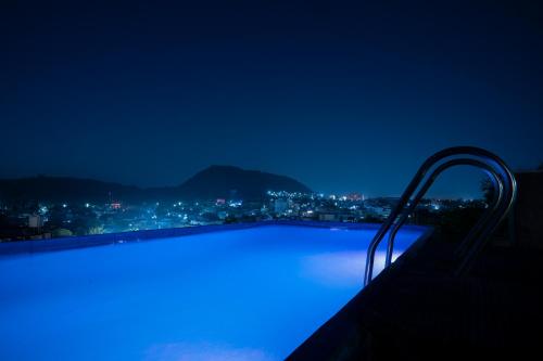 a swimming pool with blue lighting at night at Tripli Udaipur in Udaipur