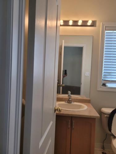 a bathroom with a sink and a mirror at Extended Stays Home in Markham