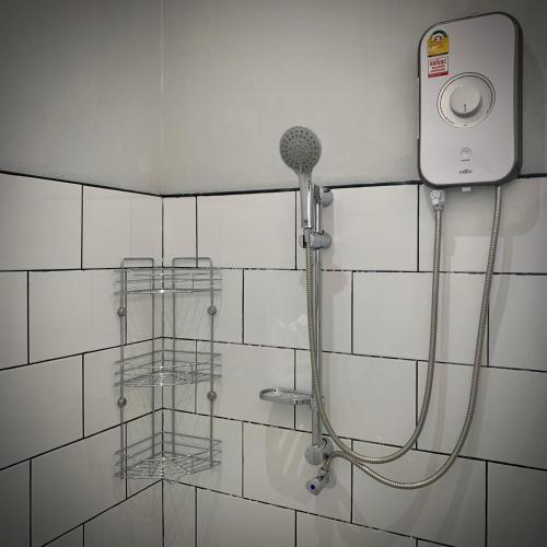 una doccia con tubo fissato a una parete piastrellata di Island House Rentals 26 a Ko Samed