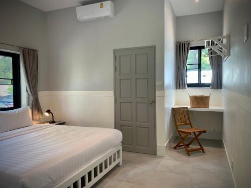 um quarto com uma cama, uma secretária e uma cadeira em Island House Rentals 26 em Ko Samet
