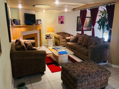 a living room with three couches and a fireplace at Casa de Luis in Tijuana