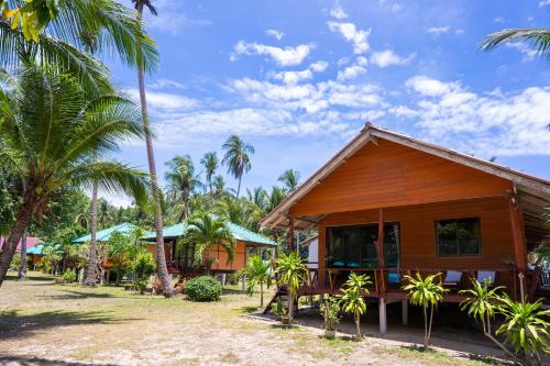 a house with palm trees in front of it at Libong Beach Resort in Ko Libong