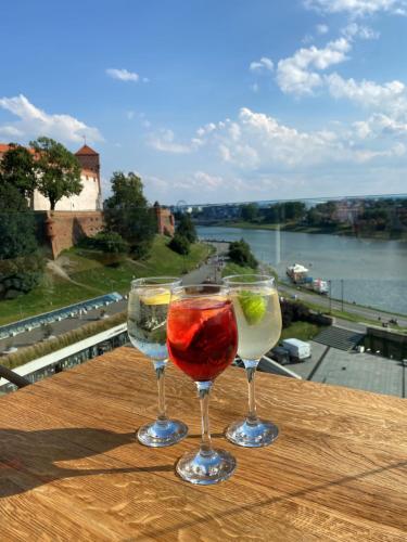 dos copas de vino sentadas sobre una mesa de madera en Hotel Pod Wawelem, en Cracovia