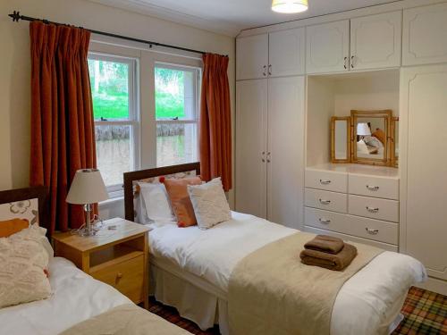 A bed or beds in a room at Sluice Keepers Cottage