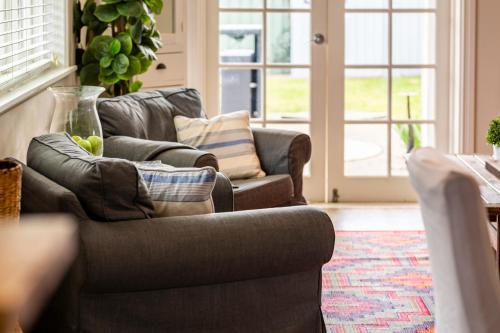 a living room with two chairs and a couch at The Edward Townhouse 155 - Steps to Town in Orange