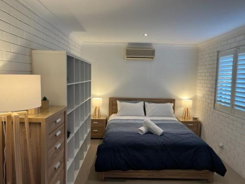 a bedroom with a bed and two lamps and a window at Harbour Side Resort in Gold Coast