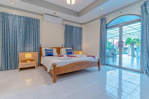 una camera da letto con un letto e una porta scorrevole in vetro di 15BR-30PAX,300m-Beach & 8mins Walking Street for Families & Group Retreat a Pattaya Sud