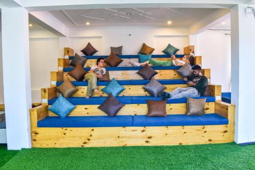 a group of people sitting on a bed with pillows at Skyard Premium, Tapovan in Rishīkesh